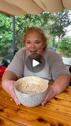 a woman sitting at a table with a bowl of food