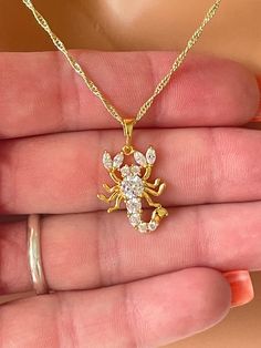 This stunning gold filled scorpion pendant necklace.   This 14kt gold filled CZ Scorpion charm measures 21x16mm, has a 6mm bail and hangs on a 14kt gold filled shiny Singapore chain chain with spring clasp closure.  Comes nicely boxed, the perfect present. Model is wearing 18" length. Available in 18" or 20" length.  Why you should choose Gold Filled Jewelry... Gold filled jewelry is an actual layer of gold pressure bonded to another metal. Gold filled is not to be confused with gold plating as Gold Scorpion, Cz Scorpion, Scorpion Necklace, Necklace Women Gold, Scorpio Necklace, Zodiac Astrology, Necklace Women, Book Decor, Summer Jewelry