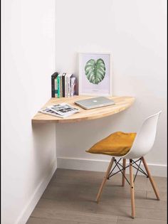 a desk with a chair and books on it in front of a wall mounted poster