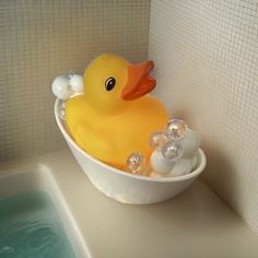 a yellow rubber duck in a bathtub with bubbles