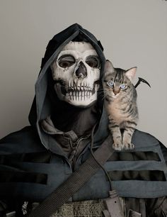 a cat sitting on the back of a man in a skeleton costume with a hood over his head