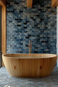 a bath tub sitting in front of a window next to a wall with blue tiles on it