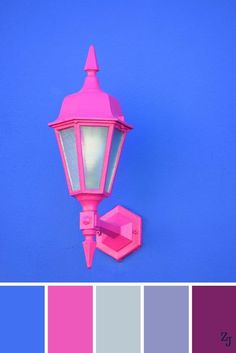 a bright pink lamp on a blue wall with color swatches in the bottom half