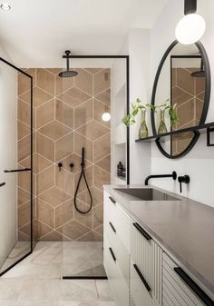 a bathroom with a walk in shower next to a sink and mirror on the wall