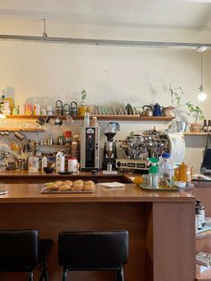 two black chairs sitting in front of a counter with coffee maker and cups on it