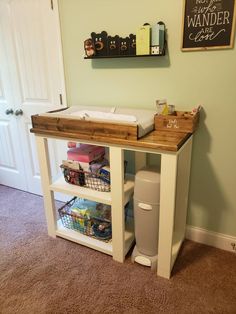 a baby changing table in the corner of a room with toys and other items on it