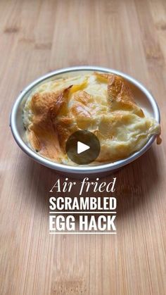 an egg and cheese dish in a bowl on a wooden table with the words air fried scrambled egg hack