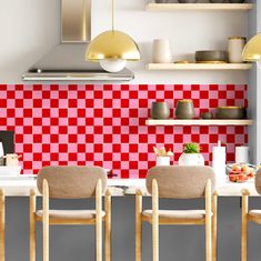 a kitchen with red and white checkered tiles on the backs of the cabinets, counter tops, and chairs