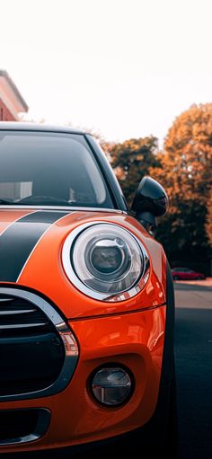 an orange and black car parked in front of a building