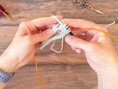 someone crocheting an object on a wooden table