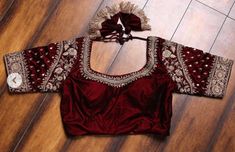 Beautiful Maroon Raw silk blouse with silver zari work all over neckline and sleeves. Note - Doris and Latkans provided are complementary so please do not complain about them. We do our best to put best latkans for you. Disclaimer - Actual colors may vary slightly due to computer monitors displaying settings. We try hard to match exact color. For sizes 42+ we charge extra $20 for fabric and workmanship. Please contact us before placing order, we will send you link to pay extra $20. Red Blouse With Silver Work, Maroon Silk Blouse Designs, Maroon Color Blouse Design, Elegant Blouse In Dola Silk With Traditional Drape, Elegant Dola Silk Blouse With Traditional Drape, Elegant Dola Silk Blouse In Traditional Drape, Elegant Embroidered Unstitched Blouse For Navratri, Elegant Semi-stitched Dola Silk Blouse, Embroidered Satin Saree