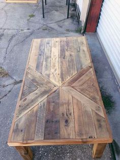 a wooden table sitting on top of a sidewalk