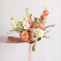 a woman holding a bouquet of flowers in her hand