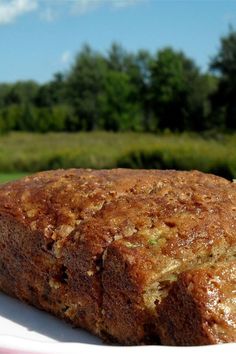 a close up of a piece of bread on a plate with trees in the background