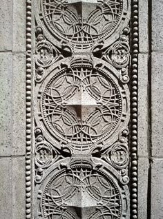 an intricate design on the side of a building in stone, with holes and circles carved into it