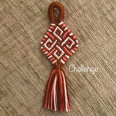 a red and white tassel hanging on top of a carpet