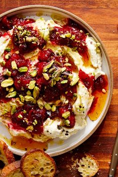 a plate with bread and cranberry sauce on it next to some crackers