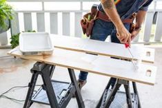 a man is working on some wooden boards