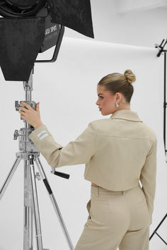 a woman standing in front of a camera on a tripod