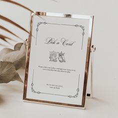 a close up of a menu on a table near a potted plant with leaves