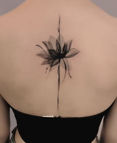 a woman's back with a flower tattoo on it