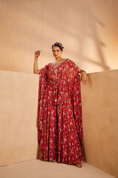 Featuring a floral-printed kaftan and sharara. The kaftan’s neckline is embroidered by hand using a mirror, sequences, and beadwork. The tie-up is accentuated with mirrors and the kaftan hem is accentuated with antique gold coins.From Aneesh Agarwaal's Seher collection.DELIVERY TIMEPlease allow 8-12 weeks for your outfit to arrive.FABRIC DETAILSChinonProfessional cleaning only. Red Georgette Sharara With Printed Motifs, Red Bohemian Maxi Sets, Festival Dress With Mirror Work And Cape Sleeves, Red Bohemian Floor-length Set, Bohemian Red Sharara With Mirror Work, Red Bohemian Sharara With Mirror Work, Red Sharara With Floral Print And Traditional Drape, Bohemian Palazzo Set With Cape Sleeves For Festive Occasions, Bohemian Floor-length Sharara With Floral Embroidery