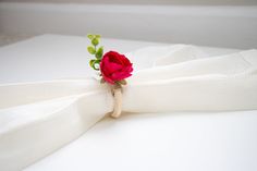 a red rose is sitting on top of a white cloth