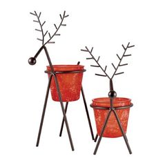 two planters with metal branches on them and one has an orange flower pot in it