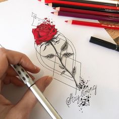 someone is drawing a rose on paper with markers