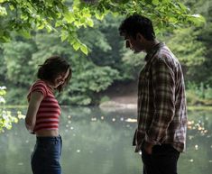 two people standing by the water looking at each other