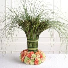 an arrangement of flowers and grass in a vase