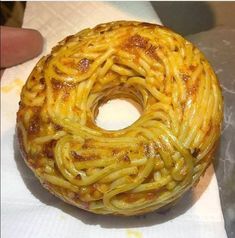 a doughnut covered in spaghetti on top of a napkin