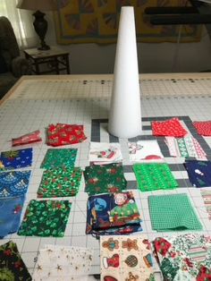 many different pieces of fabric are laid out on the floor next to a tall white pole