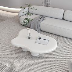 a white coffee table sitting on top of a carpeted floor next to a couch