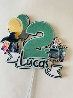 there is a cake topper with the number two in it's center and characters