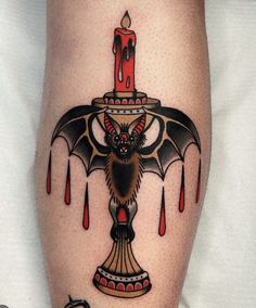 a bat with a candle on it's thigh is depicted in this tattoo design