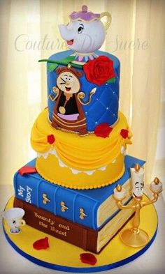 a three tiered cake is decorated with beauty and the beast characters, including an elephant