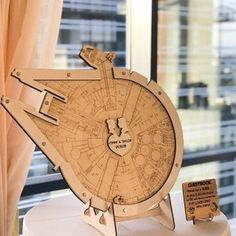 a wooden model of the star trek enterprise on display in front of a window with cityscape