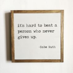 a wooden frame hanging on the wall with a quote from babe ruth about it's hard to beat a person who never gives up