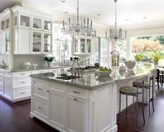 a large kitchen with white cabinets and an island