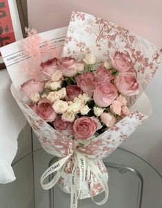 a bouquet of pink and white flowers sitting on top of a table