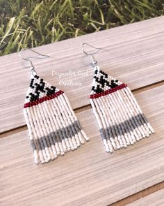 the earrings are made out of beads and beaded with red, white, and black stripes