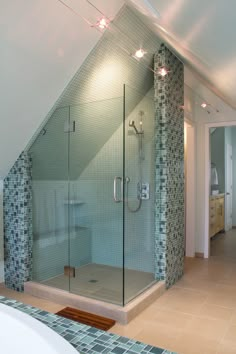 a bathroom with a walk in shower sitting next to a bathtub under a slanted ceiling