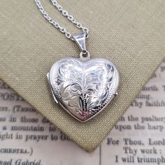 Metal: Sterling Silver Locket Size: 2.3cm x 2.1cm Locket Weight: 4 grams Chain: Faceted Belcher, 1.5mm wide, 18-24 inch Chain Weight: 3-4 grams Hallmarked: No, under 7.78 grams A beautiful sterling silver heart locket necklace with a beautiful engraved design to the front, and a brushed finish to the reverse. This is a good sized locket, with room inside to hold two photos of your loved ones. Available on a chain in 18, 20, 22 or 24 inch lengths. *RETURNS* We accept returns within 30 days, provi Silver Heart Locket, Sterling Silver Locket, Silver Locket, Heart Locket Necklace, Engraved Design, Silver Lockets, Heart Locket, Sterling Silver Heart, Locket Necklace