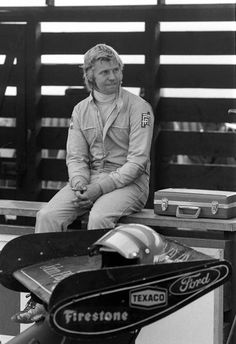 a man sitting on top of a wooden bench next to a black and white photo