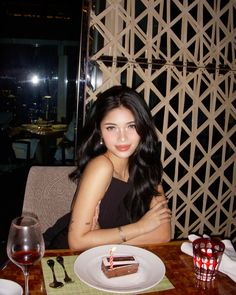 a woman sitting at a table with a piece of cake in front of her,