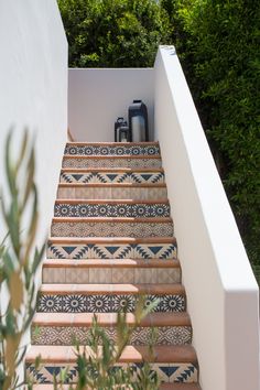 the stairs are decorated with blue and white tiles, along with a potted plant