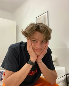 a young man sitting on top of an orange chair