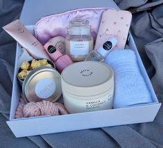 an open box containing various items such as candles, soaps and other personal care products