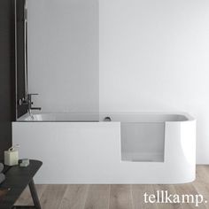 a white bath tub sitting on top of a wooden floor